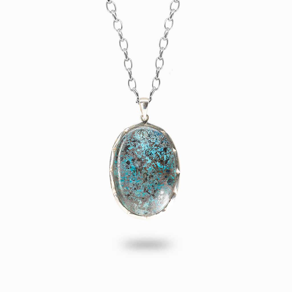 Oval Shattuckite pendant necklace featuring turquoise-blue, brown, and charcoal mineral patterns in a sterling silver setting.