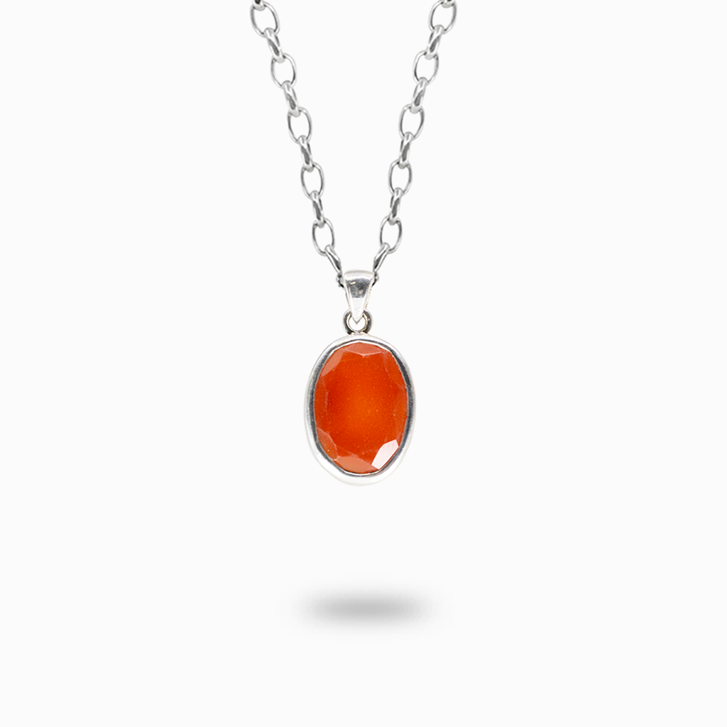 Faceted oval orange Carnelian pendant necklace in a polished sterling silver bezel setting.