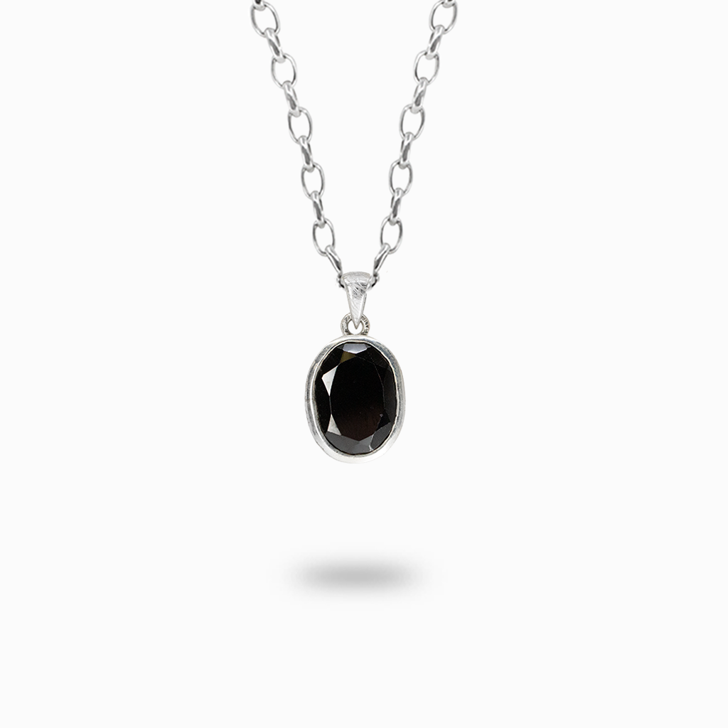Faceted oval Black Onyx pendant necklace with a deep black polished surface in a sterling silver bezel setting.