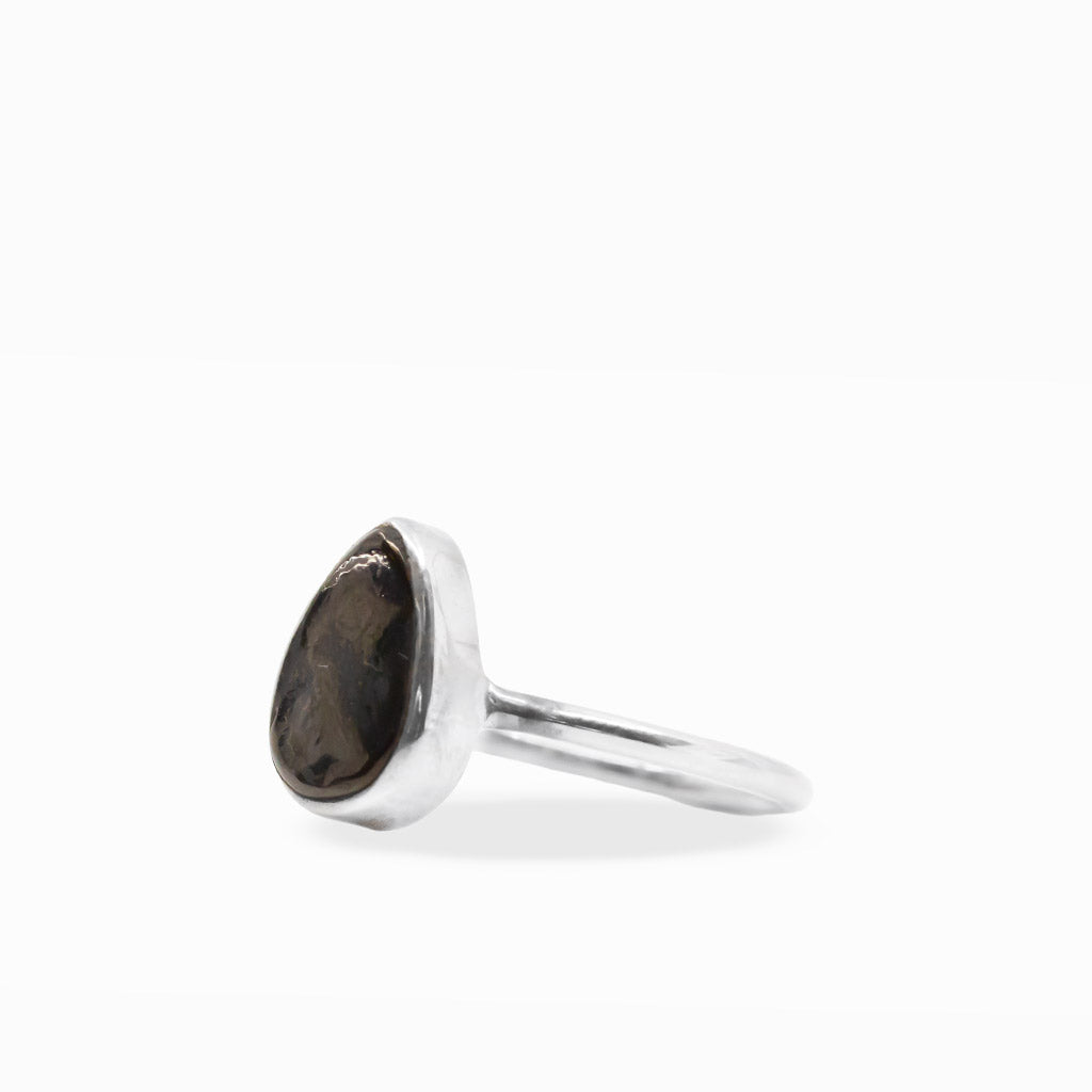 Black pear-shaped Shungite gemstone ring with polished sterling silver bezel setting and delicate split band.