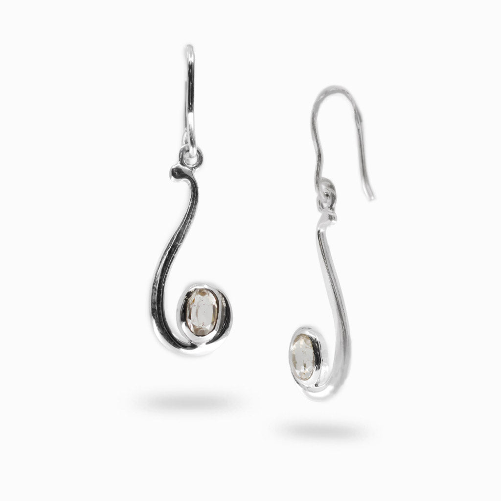 A pair of silver drop earrings with a curved, openwork design and a small oval clear quartz at the bottom, shown on a light gray background.