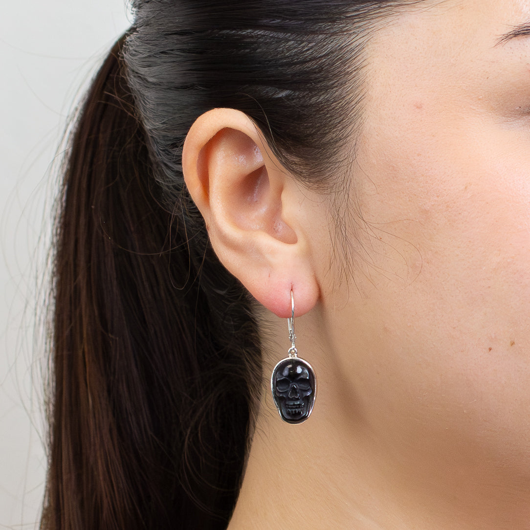 Black Obsidian skull drop earrings set in sterling silver with polished dark gemstone carving.| MADE IN EARTH
