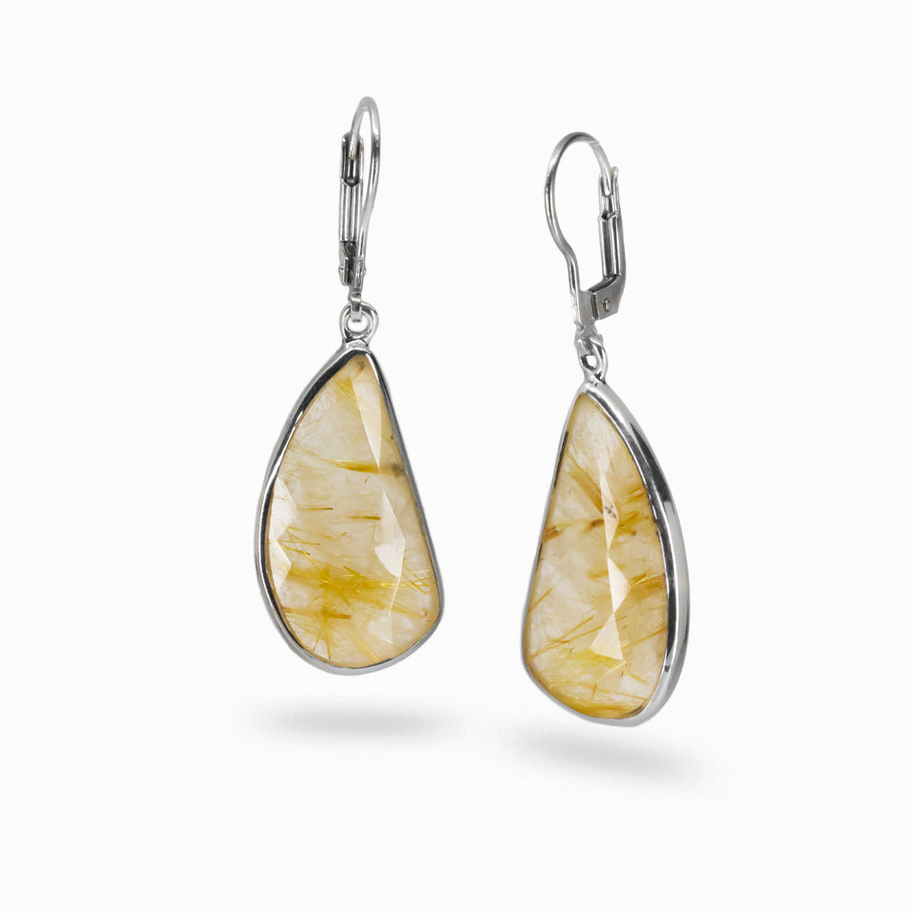 Faceted golden rutilated quartz drop earrings with visible gold rutile threads set in sterling silver lever-back hooks. | MADE IN EARTH