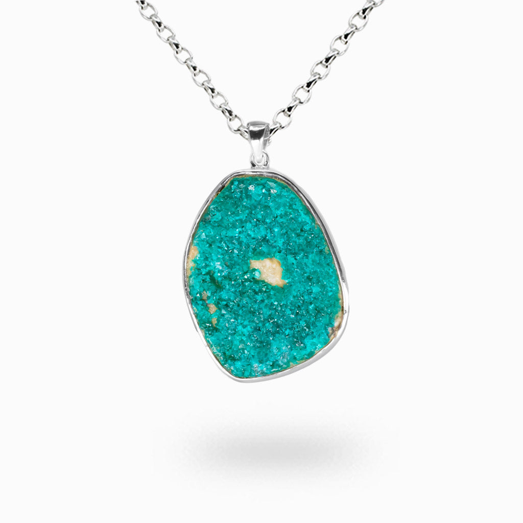 Vivid green dioptase druzy crystal cluster on white matrix set in a sterling silver bezel pendant on a silver chain.