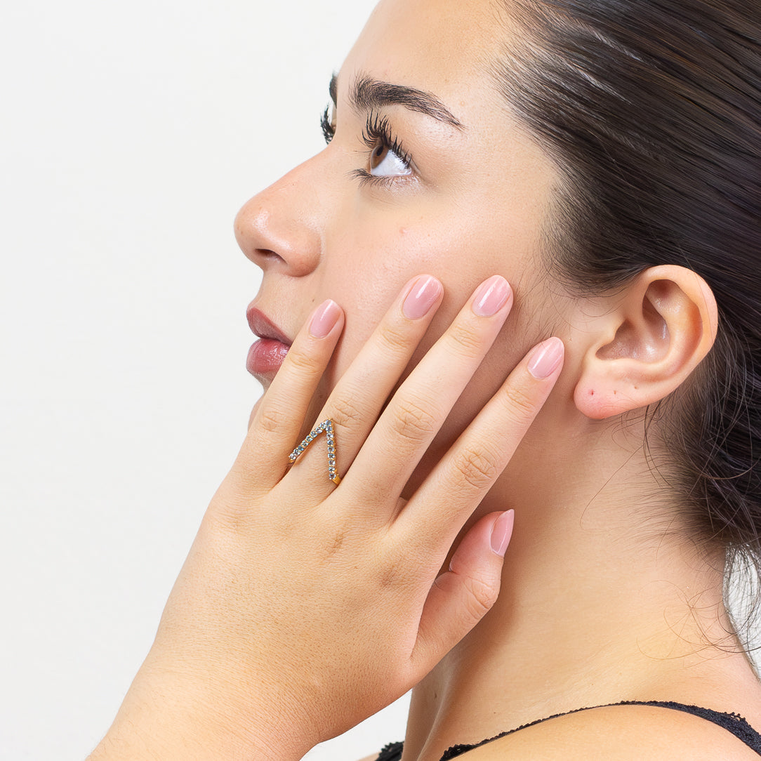 Dazzling Blue Topaz V-Shaped gold vermeil ring. A radiant gemstone of love, success, confidence, and manifestation. Modern chevron design with brilliant sparkle on model. | MADE IN EARTH