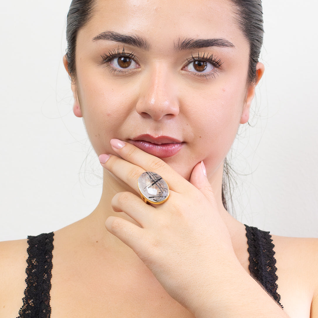 Oval Black Tourmalinated Quartz ring in yellow gold vermeil with bold black inclusions inside clear quartz on model. | MADE IN EARTH