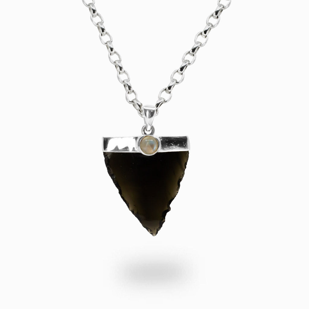 Raw Apache Tear Obsidian arrowhead pendant necklace featuring a Rainbow Moonstone accent set in a sterling silver cap.