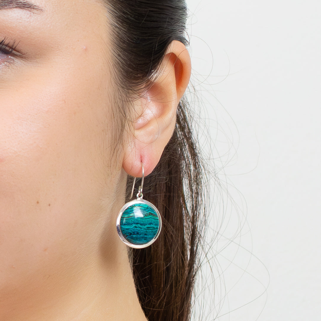 Round Chrysocolla and Malachite cabochon sterling silver drop earrings with French hooks, featuring vibrant blue-green layered patterns ON MODEL. | MADE IN EARTH