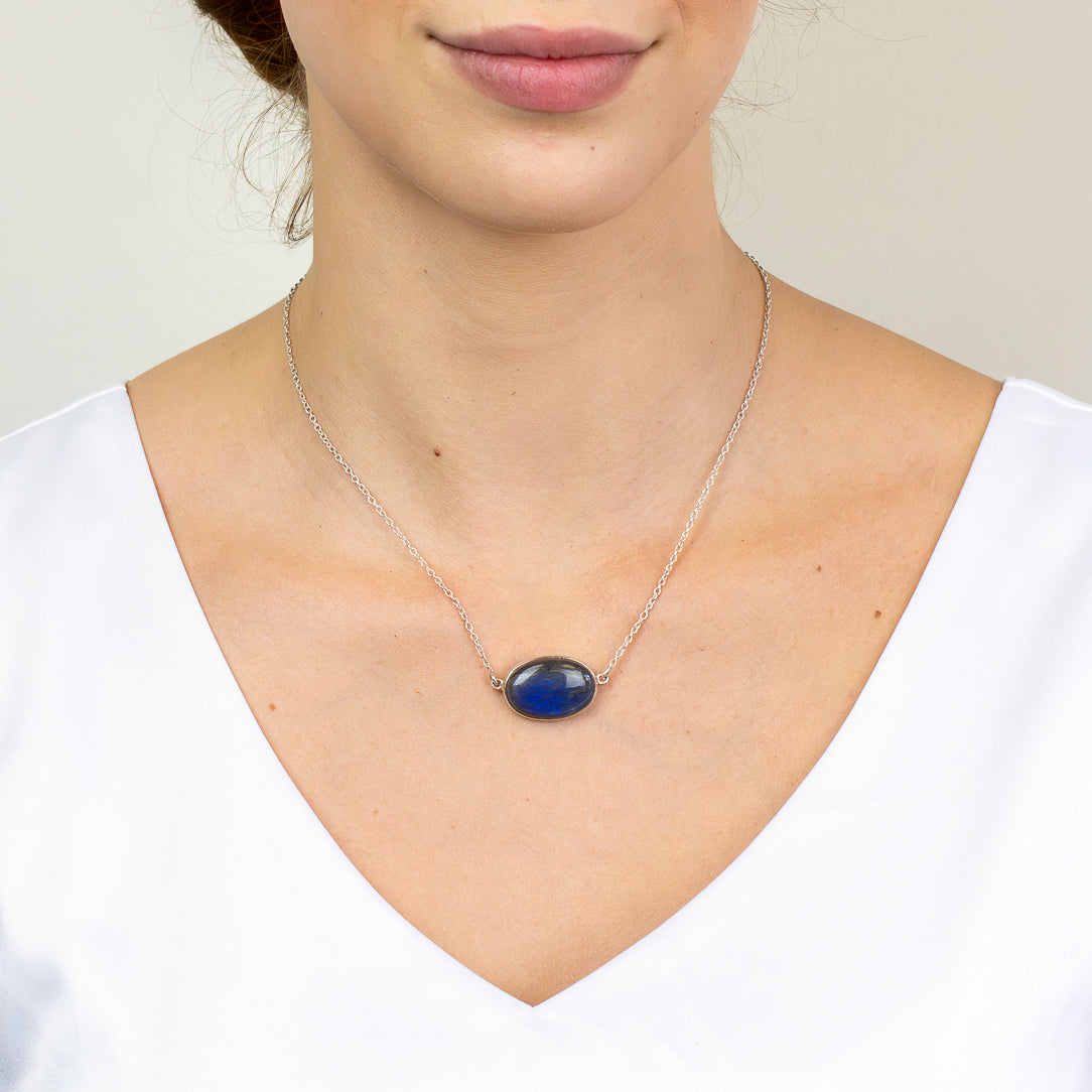 Labradorite necklace in sterling silver featuring a polished oval cabochon with natural iridescent flash.