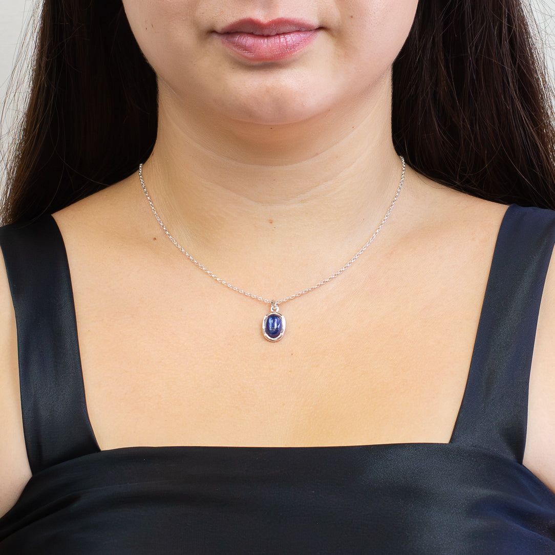 Blue Kyanite cabochon pendant set in sterling silver on a chain on model. | MADE IN EARTH