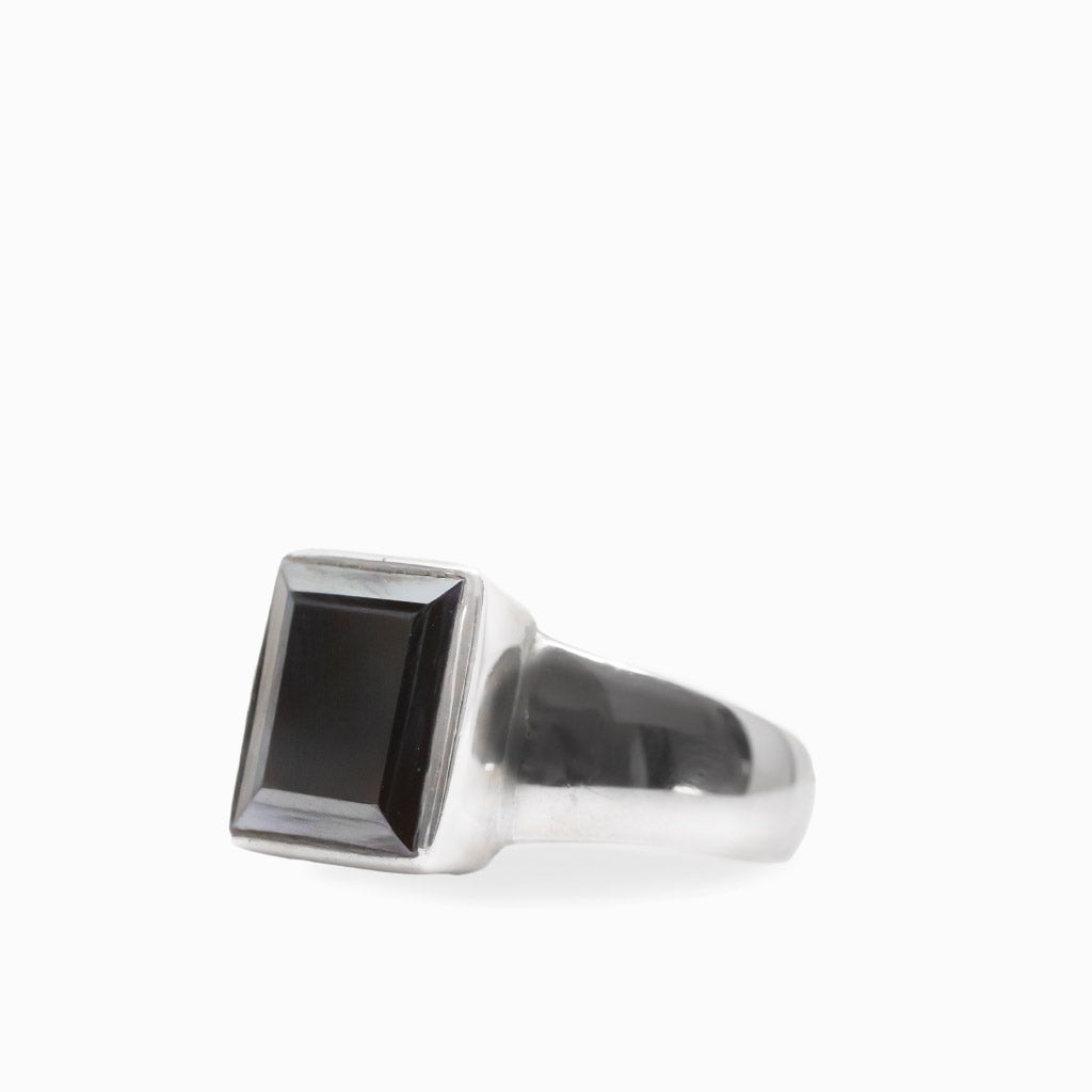 Dark metallic rectangular faceted Hematite gemstone set vertically in a polished 925 sterling silver ring.
