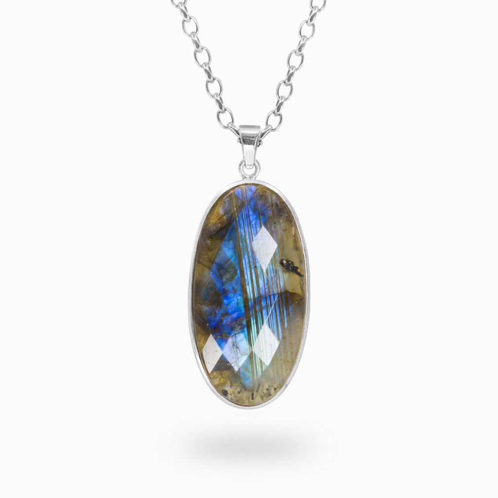 Elongated oval faceted Labradorite pendant with iridescent blue flashes in a polished 925 sterling silver bezel setting.
