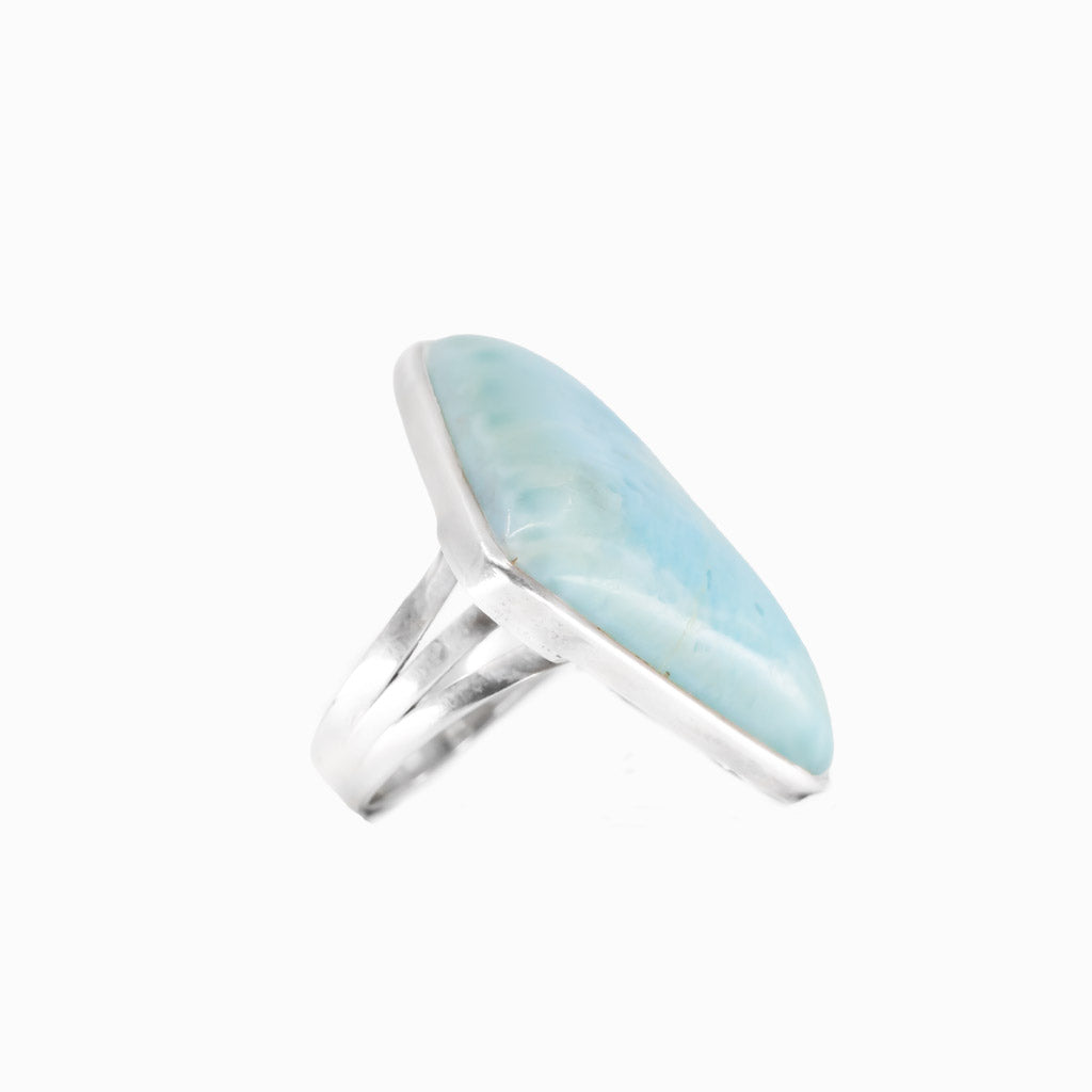 Larimar triangle cabochon ring in sterling silver bezel. Ocean-blue gemstone with natural marbling in a modern, sculptural design.