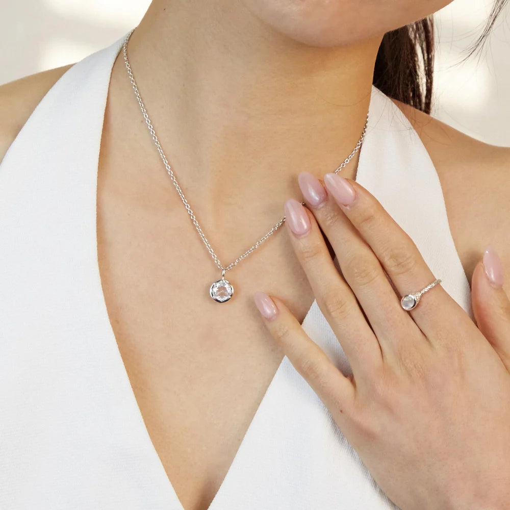 Round faceted transparent Clear Quartz gemstone set in polished sterling silver pendant necklace.