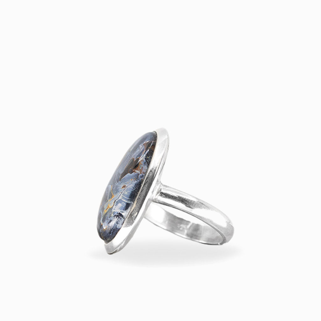 Elongated oval Pietersite ring with swirling midnight-blue, charcoal, and golden-brown patterns in polished sterling silver.