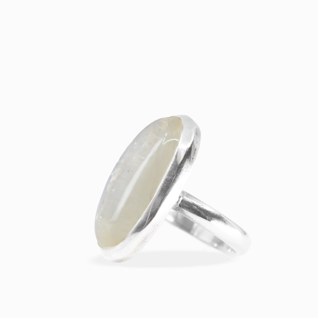 Large oval Rainbow Moonstone ring with milky-white cabochon, subtle iridescent sheen, and polished sterling silver bezel setting.