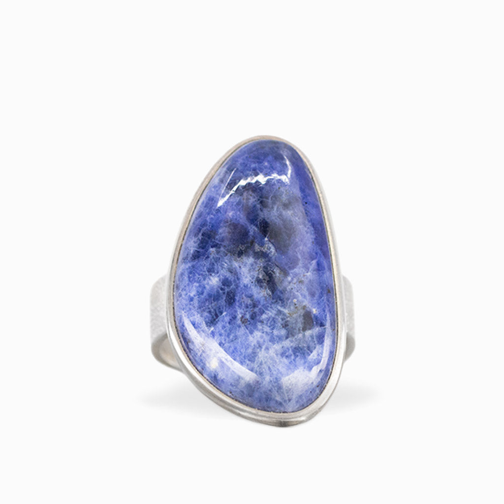 Freeform Sodalite ring with deep royal-blue cabochon, natural white veining, and polished sterling silver bezel setting.