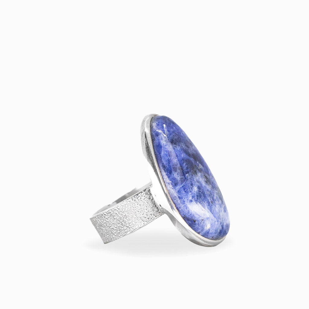 Freeform Sodalite ring with deep royal-blue cabochon, natural white veining, and polished sterling silver bezel setting.