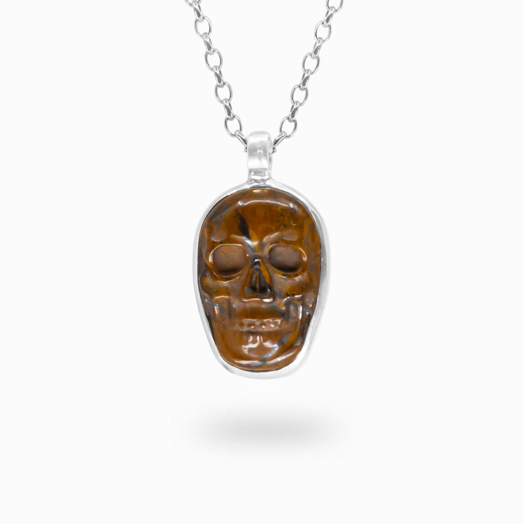 Carved brown Tiger Iron skull pendant with polished details in a 925 sterling silver setting.