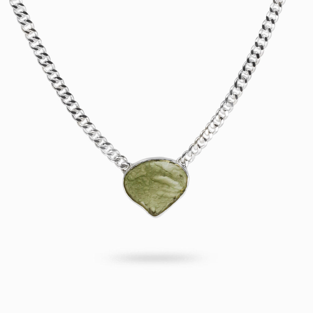 Organic teardrop-shaped raw moldavite pendant with natural textured green surface set in sterling silver with attached silver chain. | MADE IN EARTH