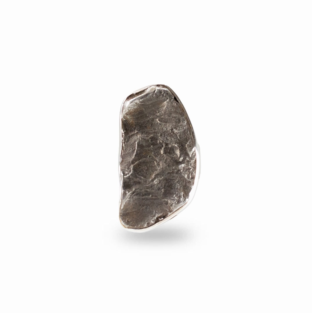 Raw dark metallic Sikhote-Alin Meteorite fragment framed in a polished sterling silver ring setting.
