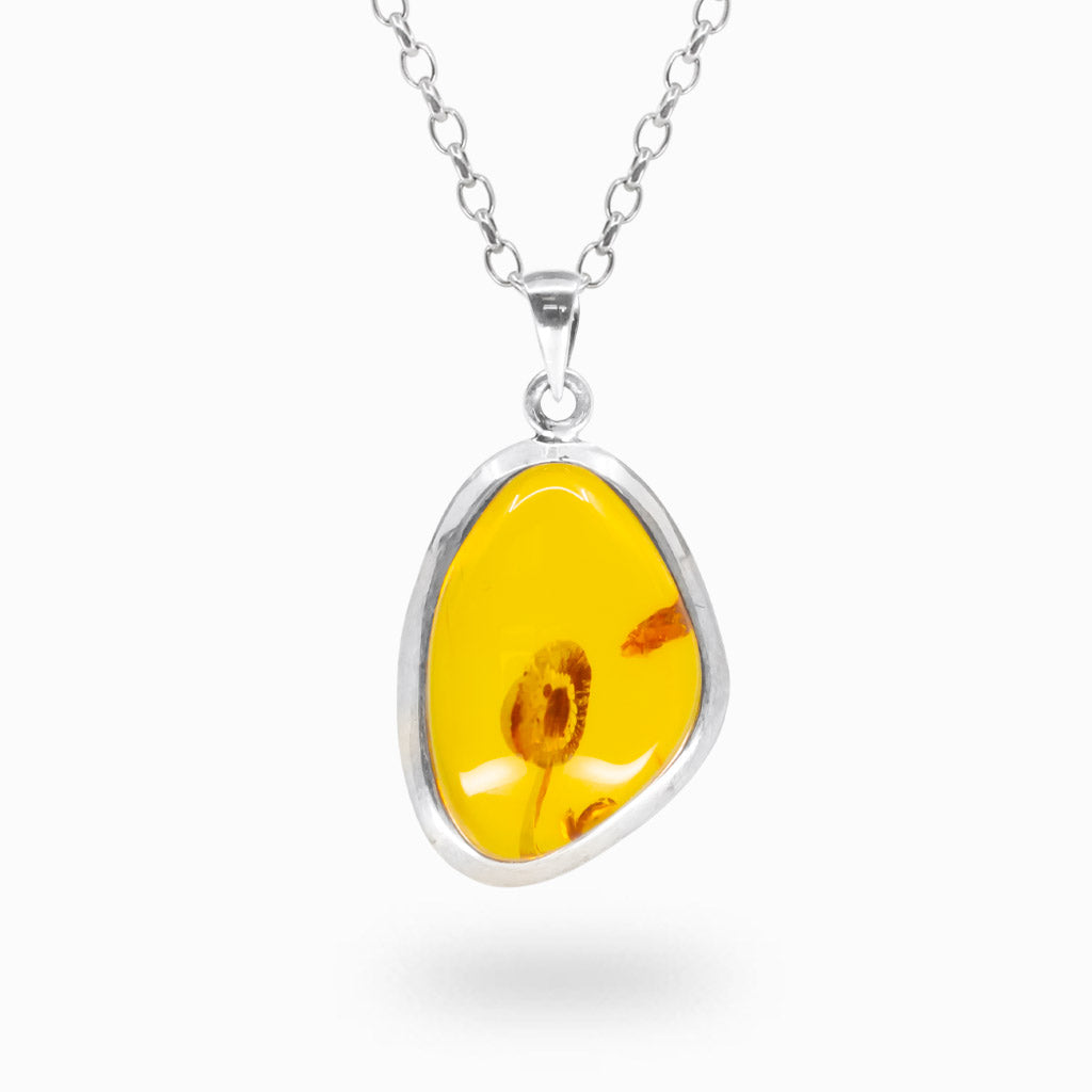 Freeform golden yellow Amber pendant with visible preserved inclusions in a polished 925 sterling silver bezel setting.