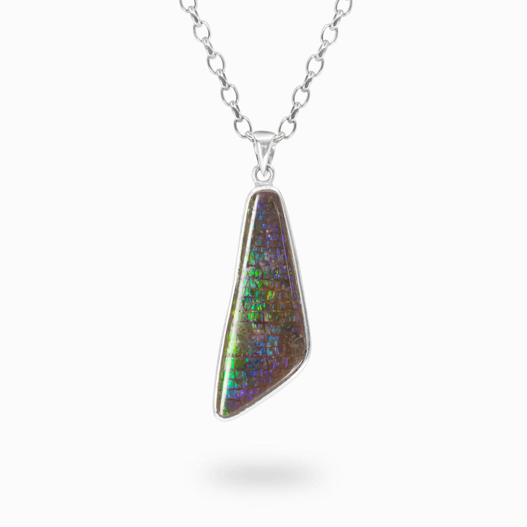 Asymmetrical Ammolite pendant with iridescent green, blue and violet colors in a polished 925 sterling silver bezel setting.