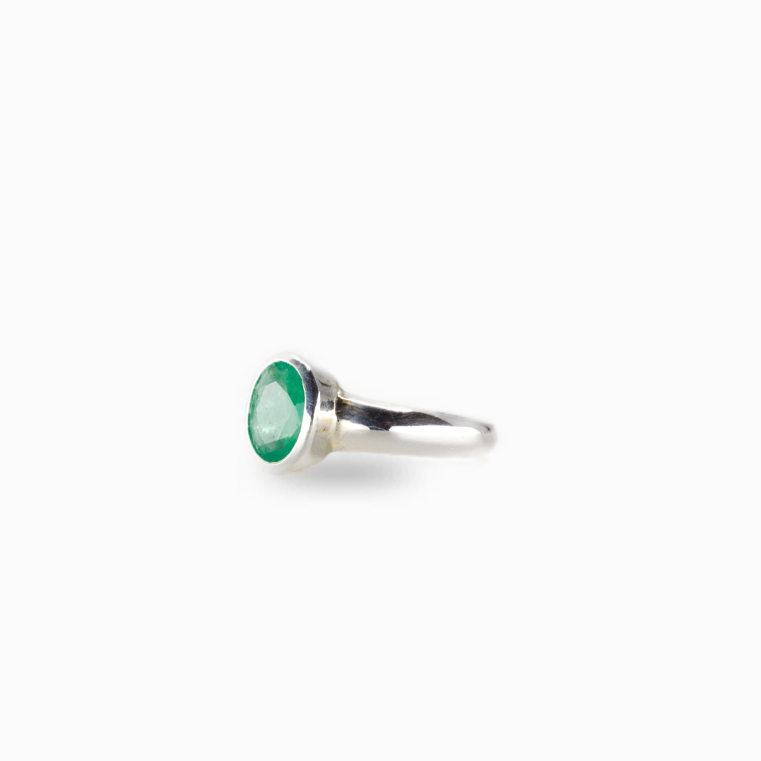 Emerald gemstone ring with vibrant green oval stone set in sterling silver band