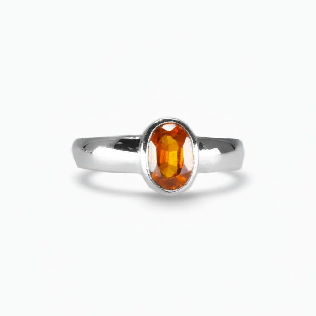 Oval faceted Hessonite Garnet ring in sterling silver with warm orange-amber tones on a white background | MADE IN EARTH