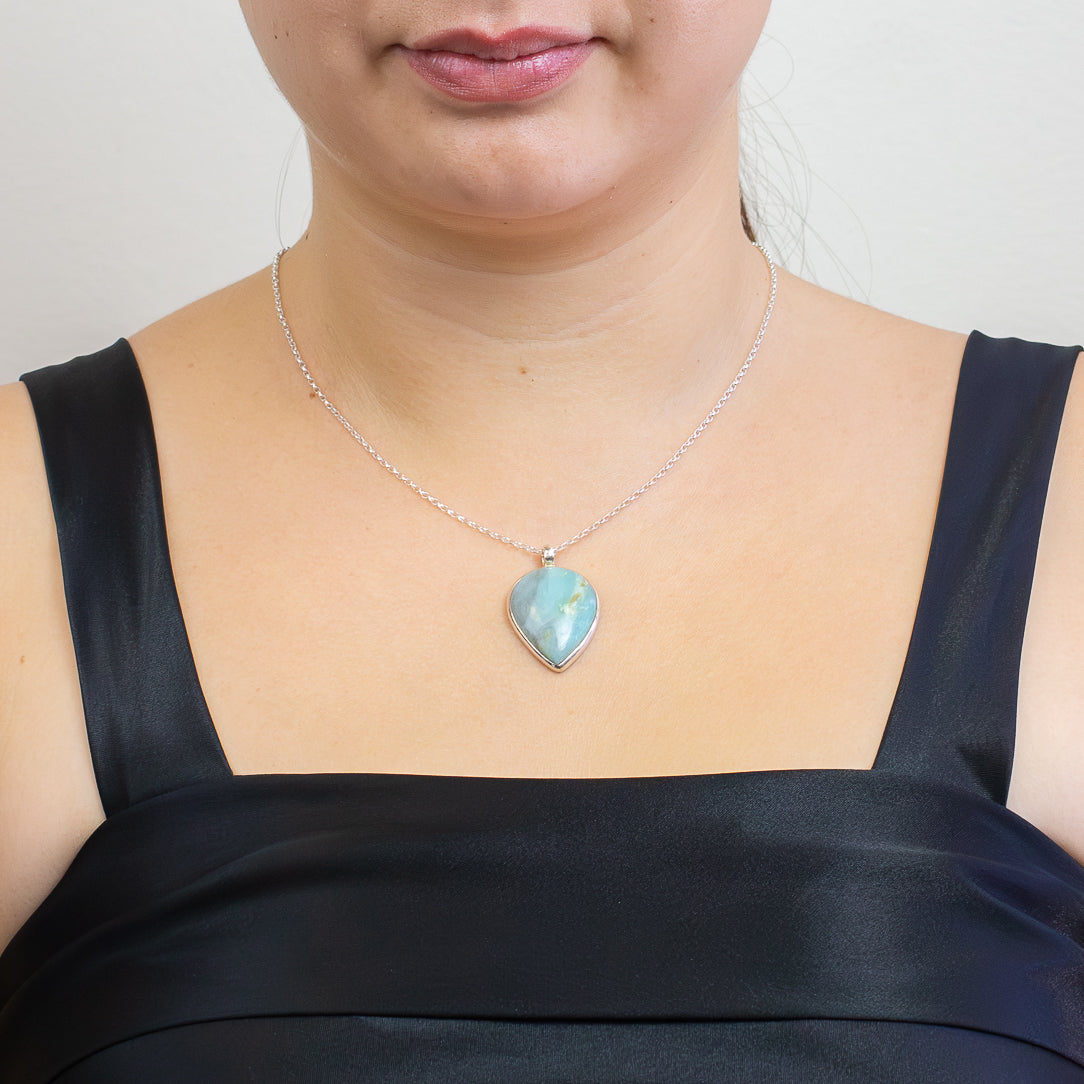Teardrop-shaped Andean Opal pendant with soft aqua and white patterns set in sterling silver on a chain. | MADE IN EARTH