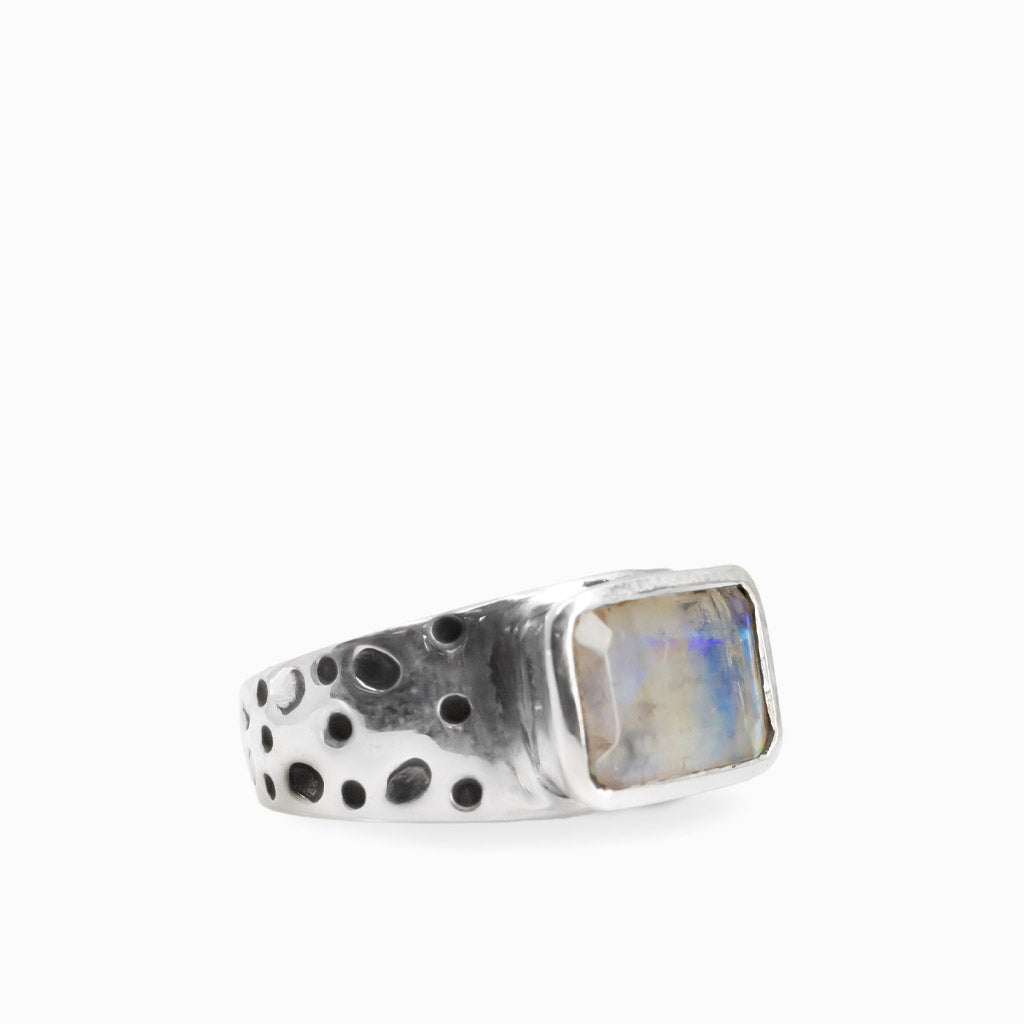 Rectangular Rainbow Moonstone cabochon with subtle iridescent flashes set in a textured 925 sterling silver ring.Rectangular Rainbow Moonstone cabochon with subtle iridescent flashes set in a textured 925 sterling silver ring.
