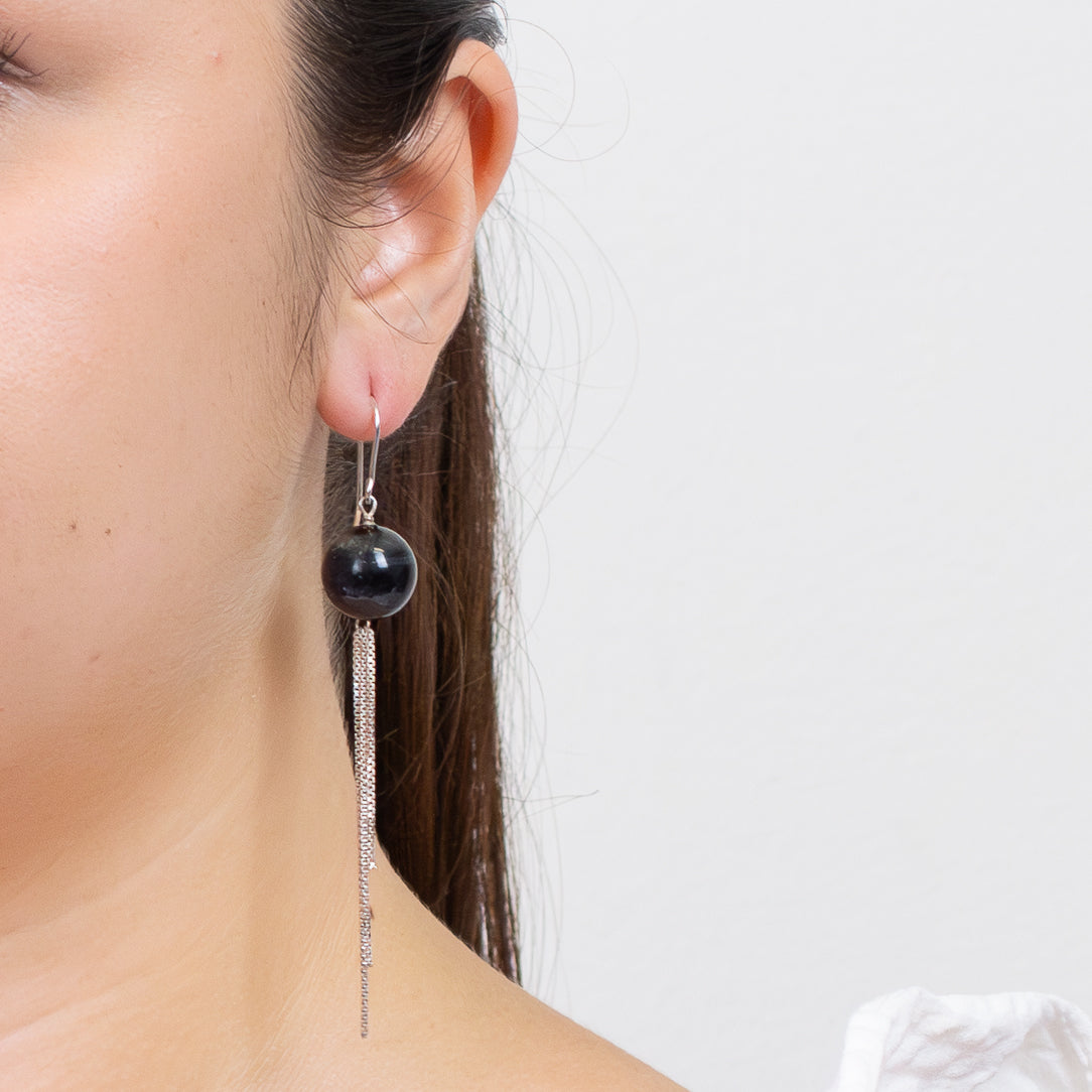 Hawk’s Eye round gemstone earrings with sterling silver multi-chain fringe, photographed on a white background on model. | MADE IN EARTH  