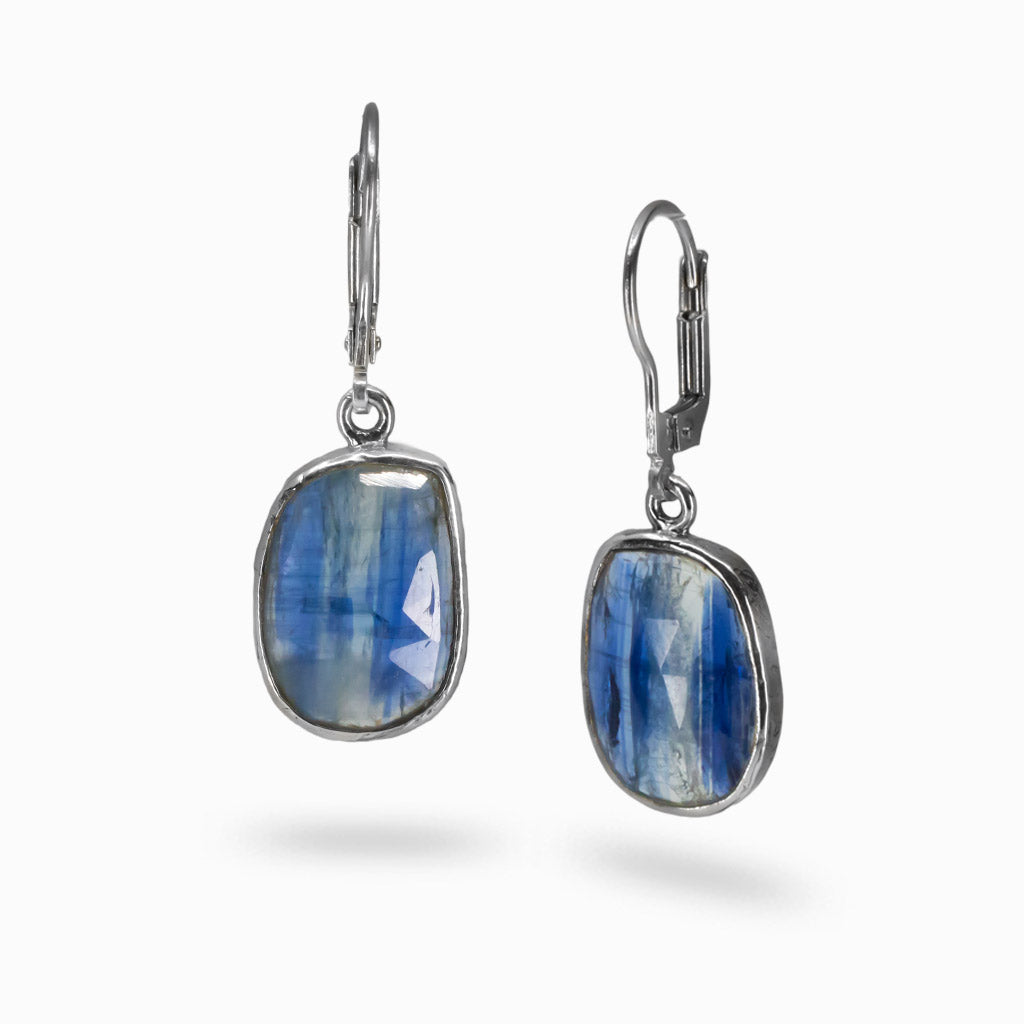 Faceted Kyanite drop earrings in sterling silver with layered blue gemstone patterns on model. | MADE IN EARTH