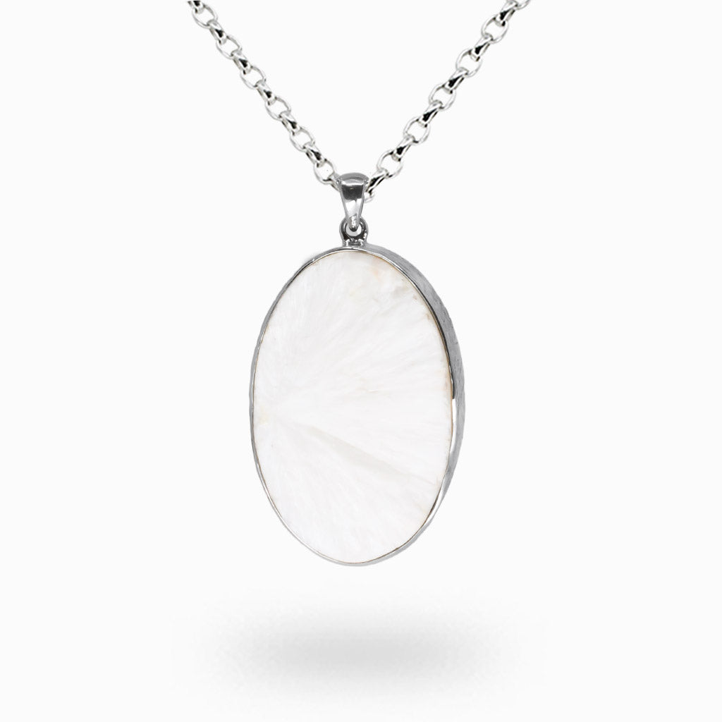 Raw white scolecite crystal cluster pendant with needle-like points set in a sterling silver bezel on a silver chain.