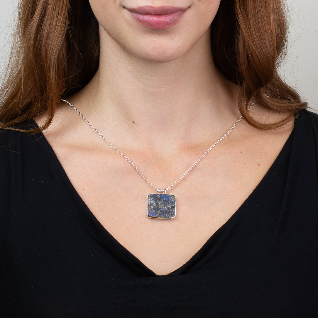 Raw rectangular Labradorite pendant necklace in sterling silver featuring natural blue and gold iridescent flashes. ON MODEL