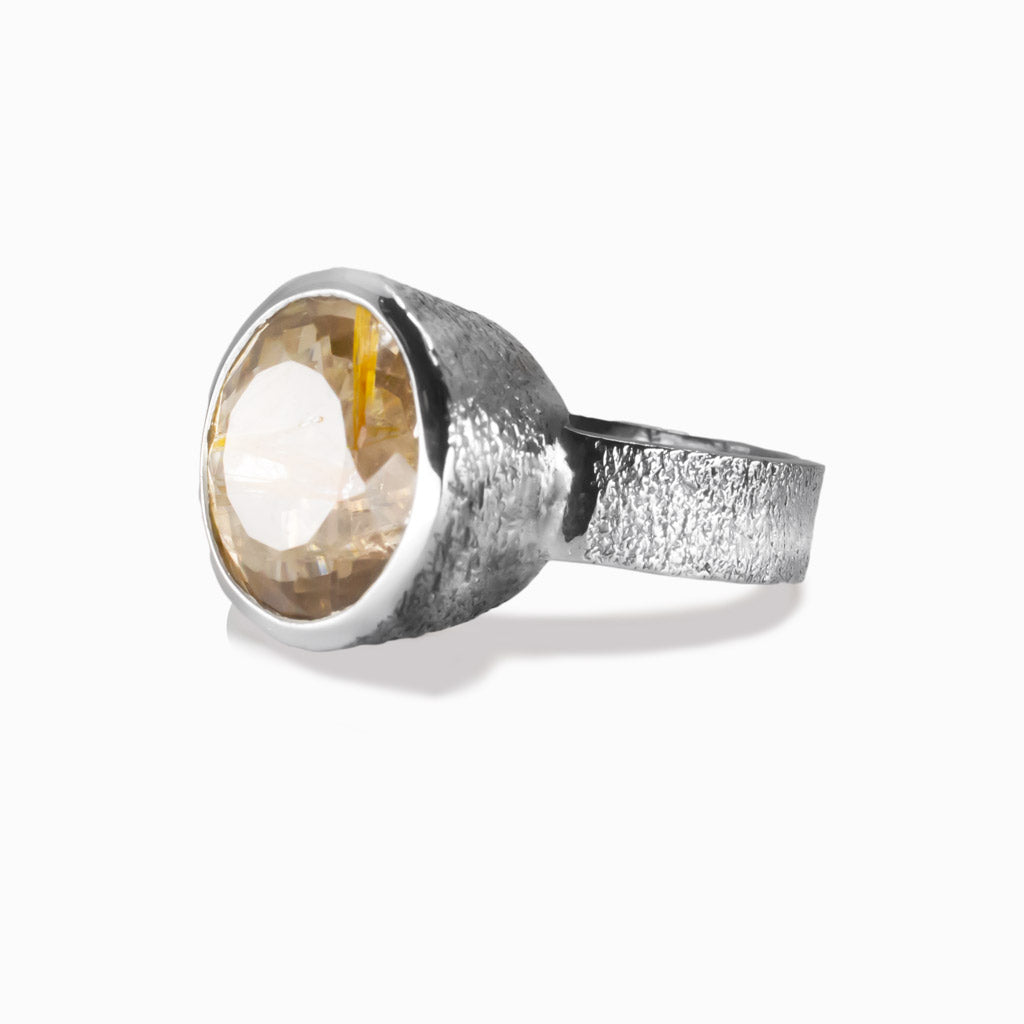 Faceted round golden rutilated quartz ring set in sterling silver bezel with golden rutile inclusions