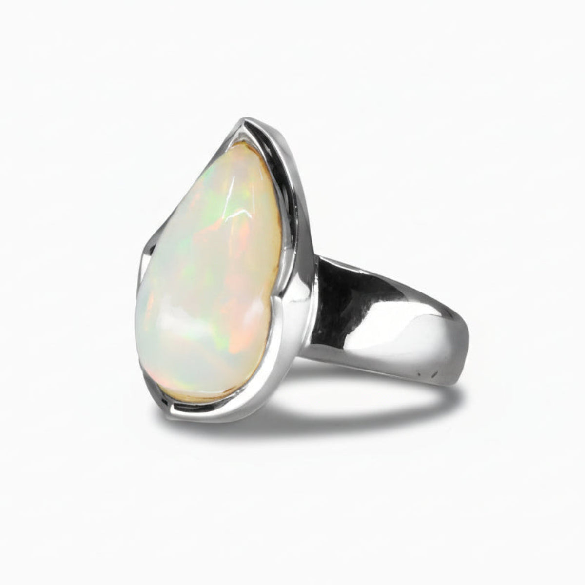 Tear shaped precious opal cabochon ring set in sterling silver with iridescent gemstone. MADE IN EARTH