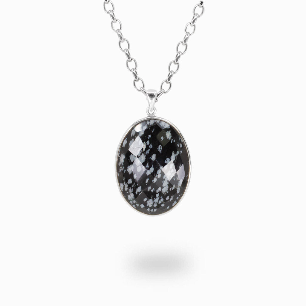 Faceted oval Snowflake Obsidian pendant necklace in sterling silver featuring black stone with natural white snowflake patterns.