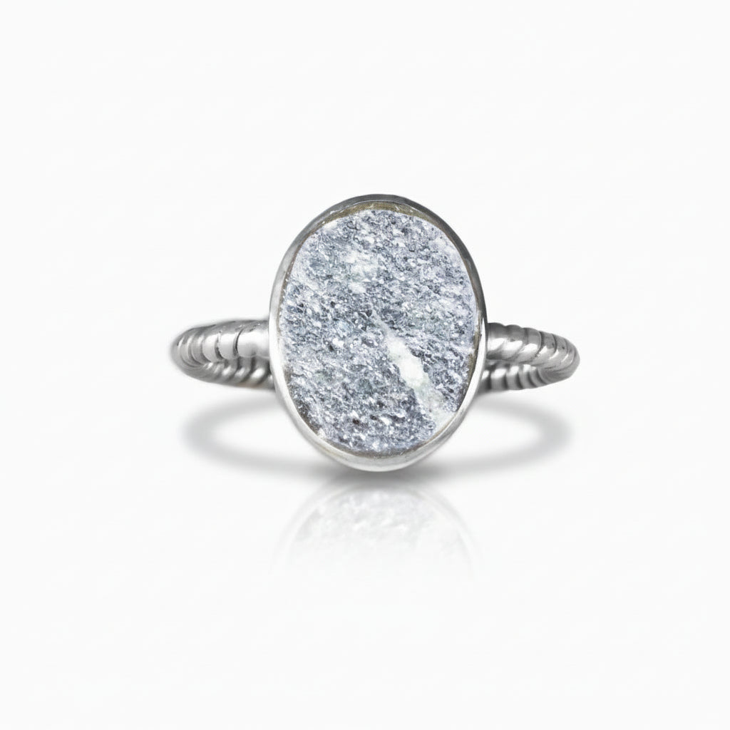 Oval silver-grey Specular Hematite cabochon ring with sparkling metallic texture set in a polished sterling silver band on a white background. | MADE IN EARTH