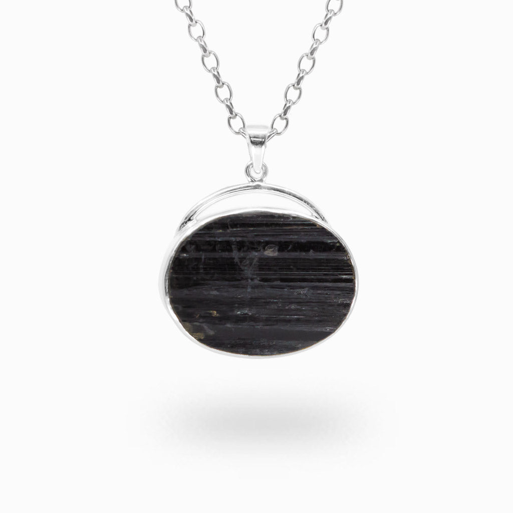 Horizontal oval Black Tourmaline pendant with natural linear striations in a polished 925 sterling silver bezel setting.