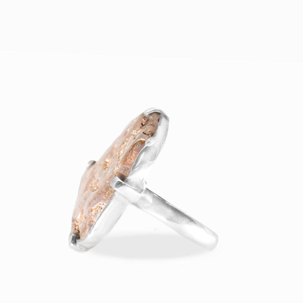 Freeform native Copper ring with warm rose-gold metallic tones, natural rough texture, and polished sterling silver prong setting.