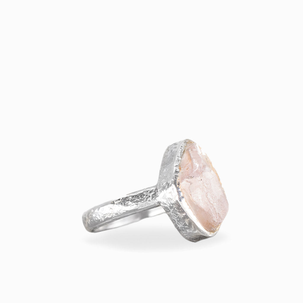 Freeform Rose Quartz ring with pale blush-pink gemstone, natural striations, textured sterling silver bezel, and matching band.