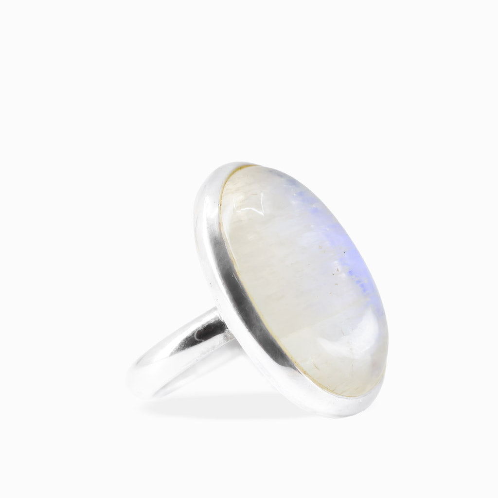 Large oval Rainbow Moonstone ring with milky-white cabochon, subtle iridescent sheen, and polished sterling silver bezel setting.