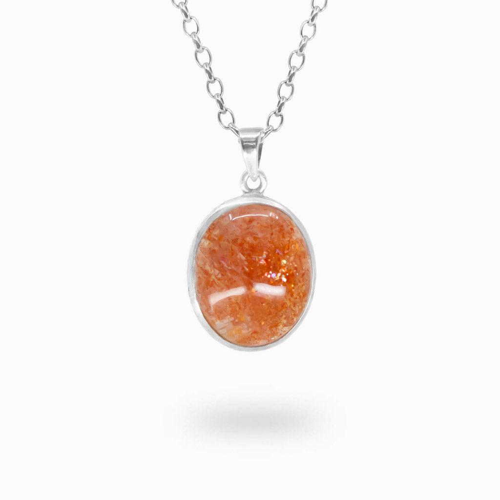 Oval orange Sunstone cabochon pendant with shimmering natural inclusions in a polished 925 sterling silver bezel setting.