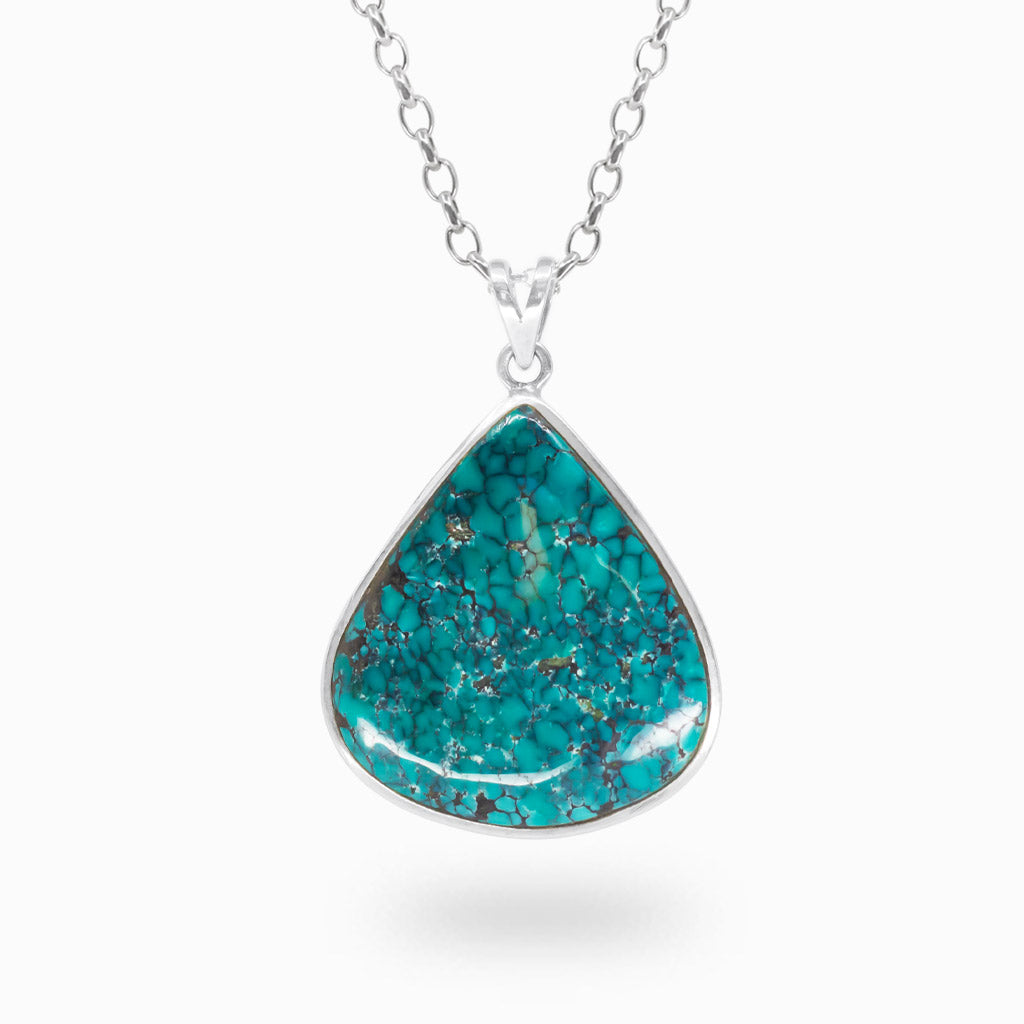 Pear-shaped blue-green Tibetan Turquoise cabochon pendant with dark matrix patterns in polished 925 sterling silver.