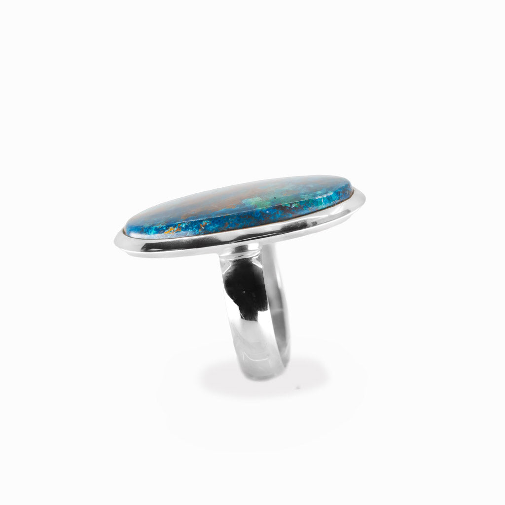 Shattuckite elongated oval cabochon ring in polished sterling silver with vivid turquoise blue and earthy copper-brown mineral patterns.