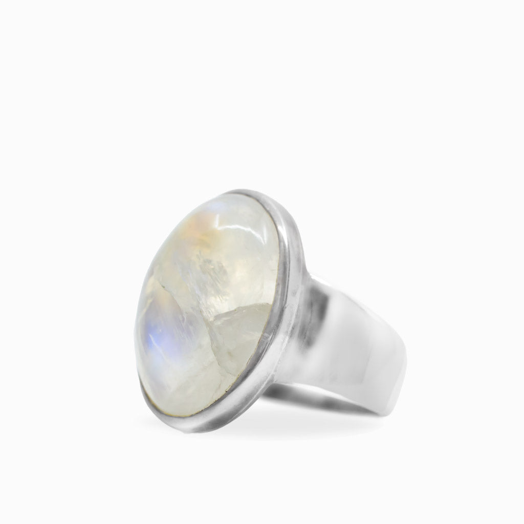 Oval Rainbow Moonstone cabochon ring with luminous white iridescence set in polished 925 sterling silver.