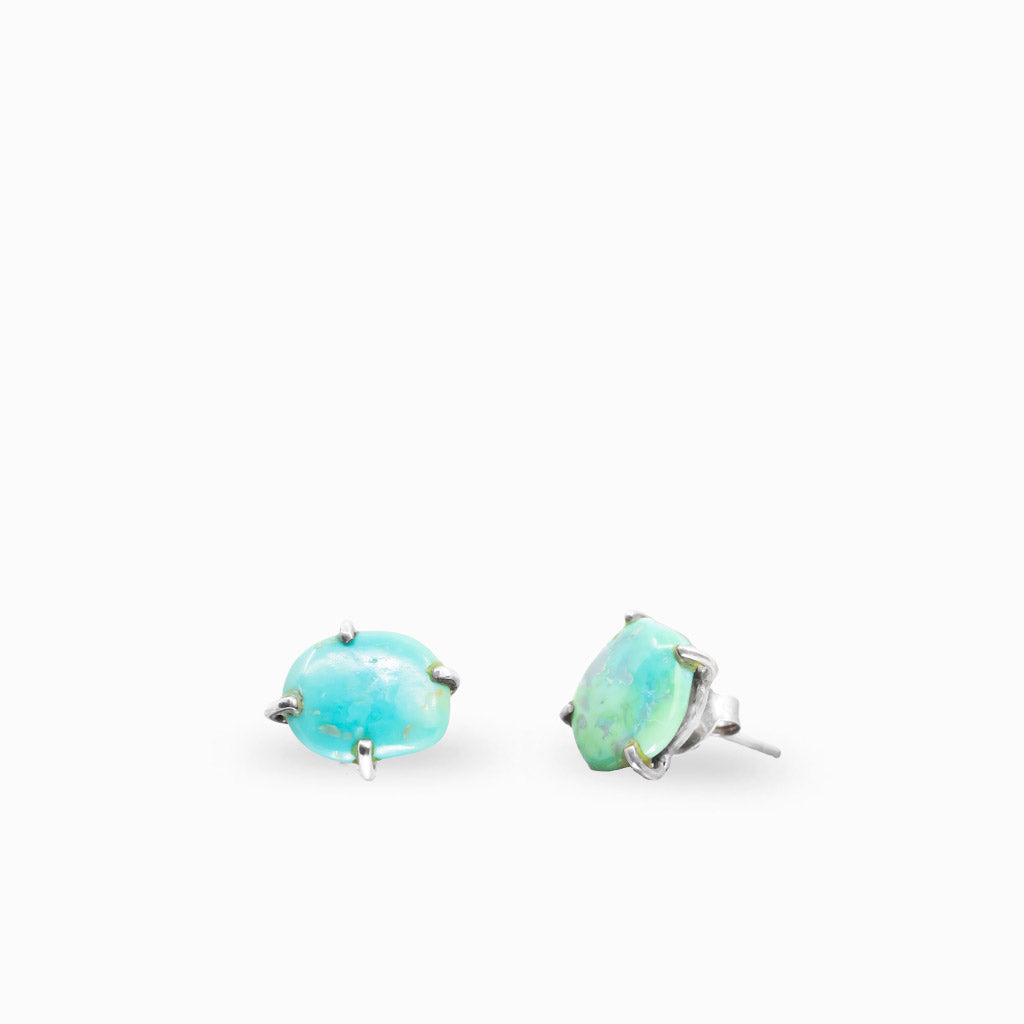 Sterling silver claw-set stud earrings featuring oval natural Turquoise gemstones.